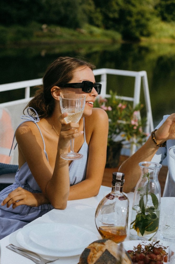 A woman enjoying a glass of rosé at golden hour